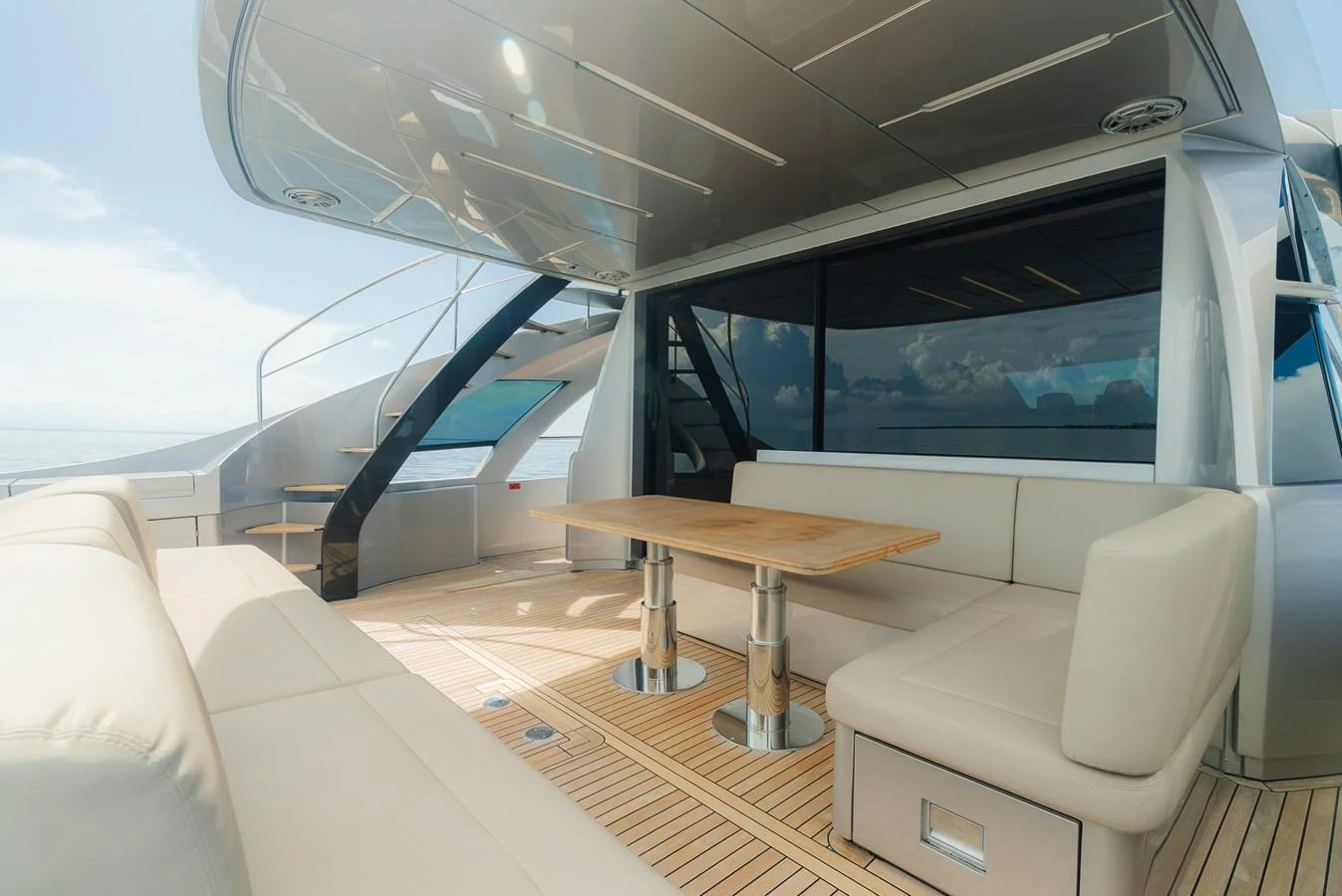 The aft deck features a spacious seating area with a wooden table, perfect for outdoor dining and relaxation. aboard NOVA Yacht for Sale