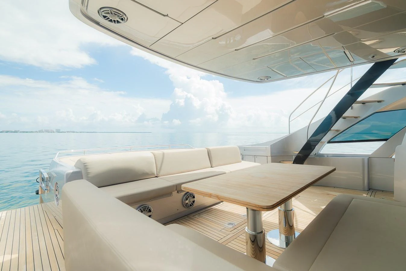 The aft deck features a spacious seating area with a wooden table, perfect for enjoying the serene ocean views. aboard NOVA Yacht for Sale