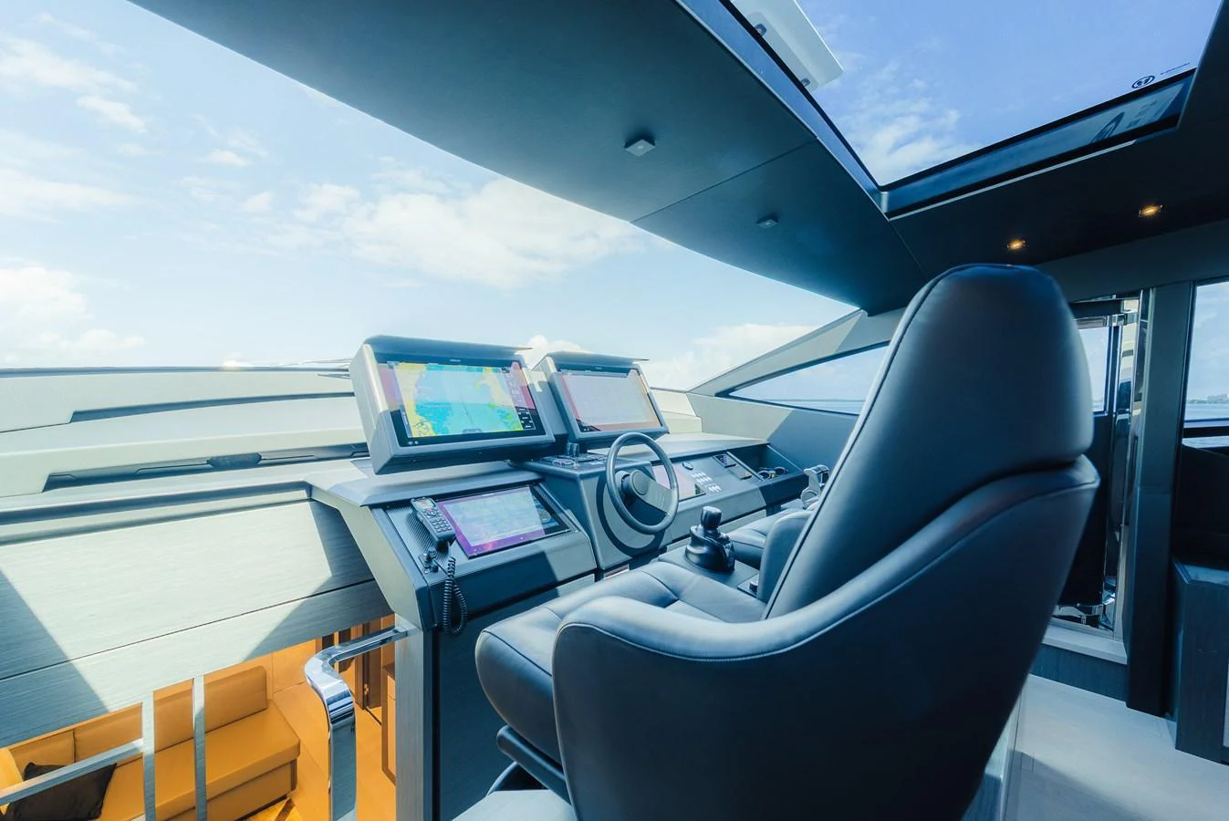 The helm station features advanced navigation equipment and a comfortable captain's chair under a skylight. aboard NOVA Yacht for Sale