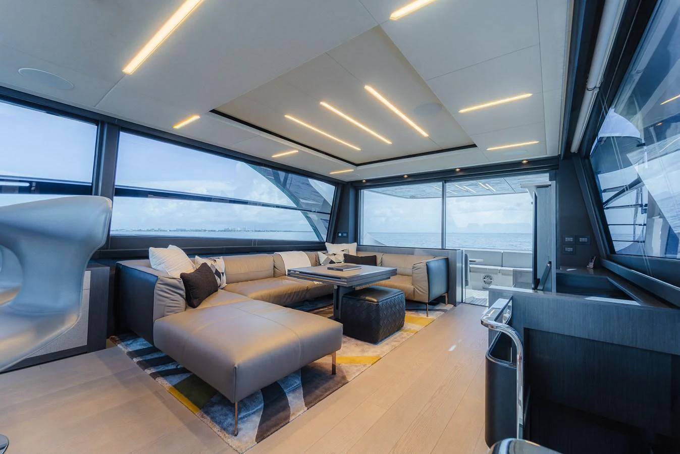The salon features modern furnishings with ample seating and panoramic windows for a luxurious and comfortable experience. aboard NOVA Yacht for Sale