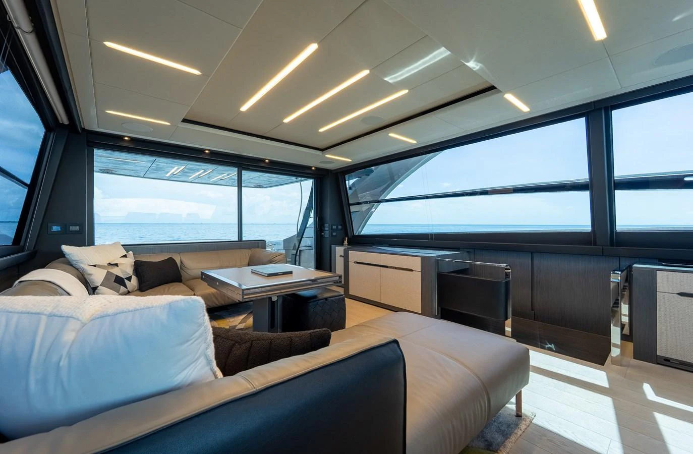 The salon features modern furnishings with expansive windows offering stunning ocean views. aboard NOVA Yacht for Sale