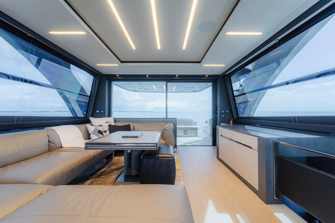 The salon features modern furnishings with panoramic windows offering stunning sea views. aboard NOVA Yacht for Sale
