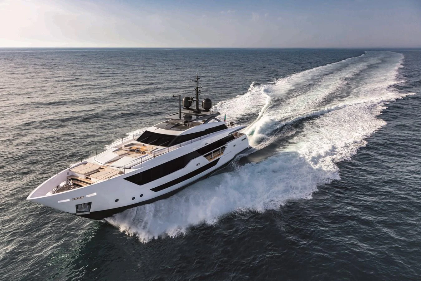 A sleek and modern yacht cruises swiftly across the open sea, leaving a trail of white wake behind. aboard CUSTOM LINE SAETTA 128/02 Yacht for Sale