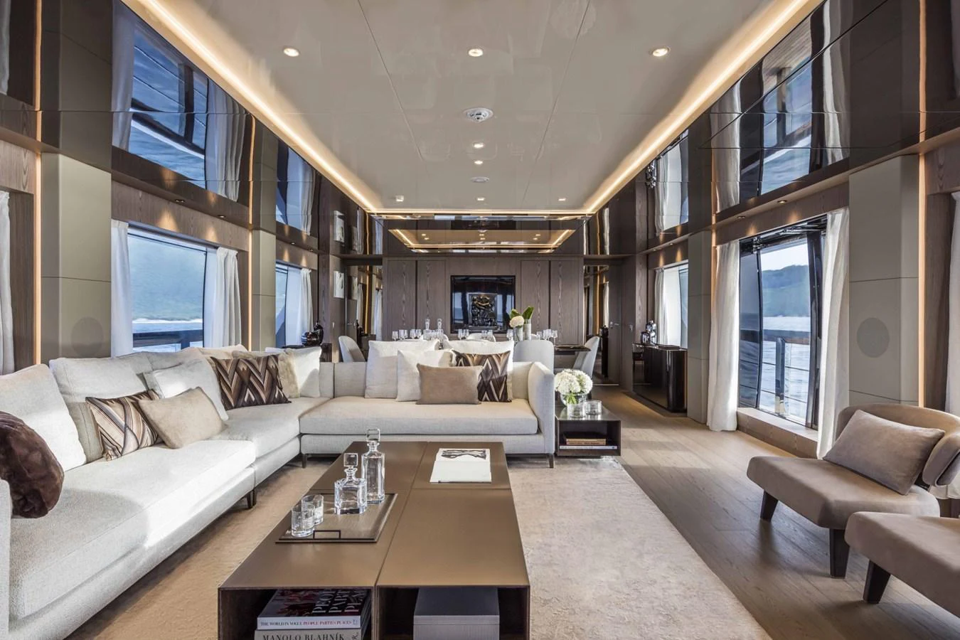 The salon features luxurious seating, elegant decor, and ample natural light through large windows. aboard CUSTOM LINE SAETTA 128/02 Yacht for Sale
