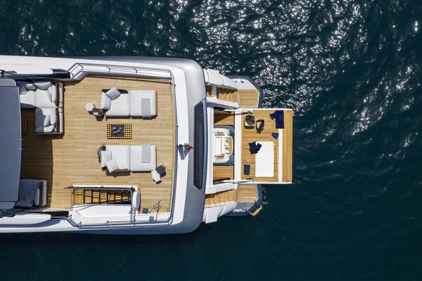 The yacht's aft deck offers a luxurious space for relaxation and sunbathing, with comfortable seating and direct access to the water. aboard CUSTOM LINE SAETTA 128/02 Yacht for Sale