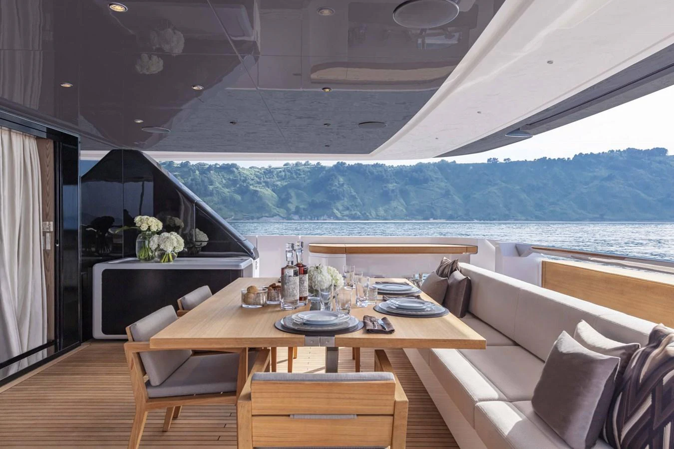 The aft deck features an elegant dining area with a scenic view. aboard CUSTOM LINE SAETTA 128/02 Yacht for Sale