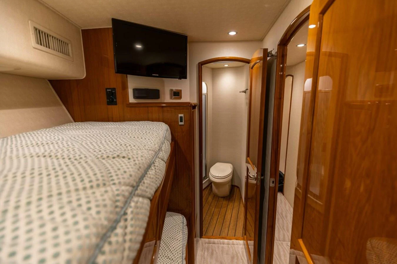 a bedroom with a bed and a television on the wall aboard MISS VIRGINIA Yacht for Sale
