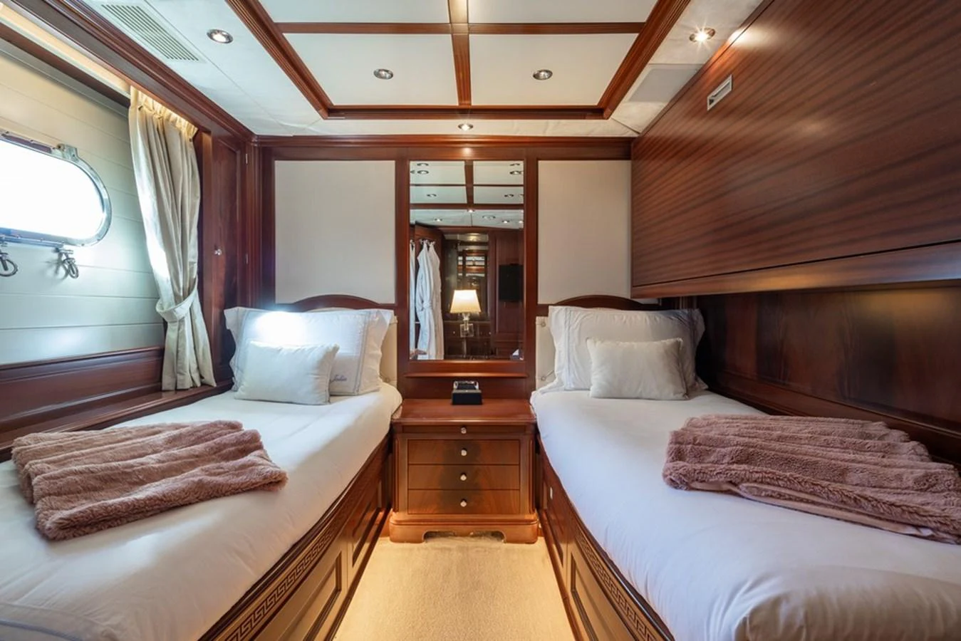 The twin stateroom offers a cozy and elegant retreat with warm wood finishes and soft lighting. aboard VIRTUE Yacht for Sale