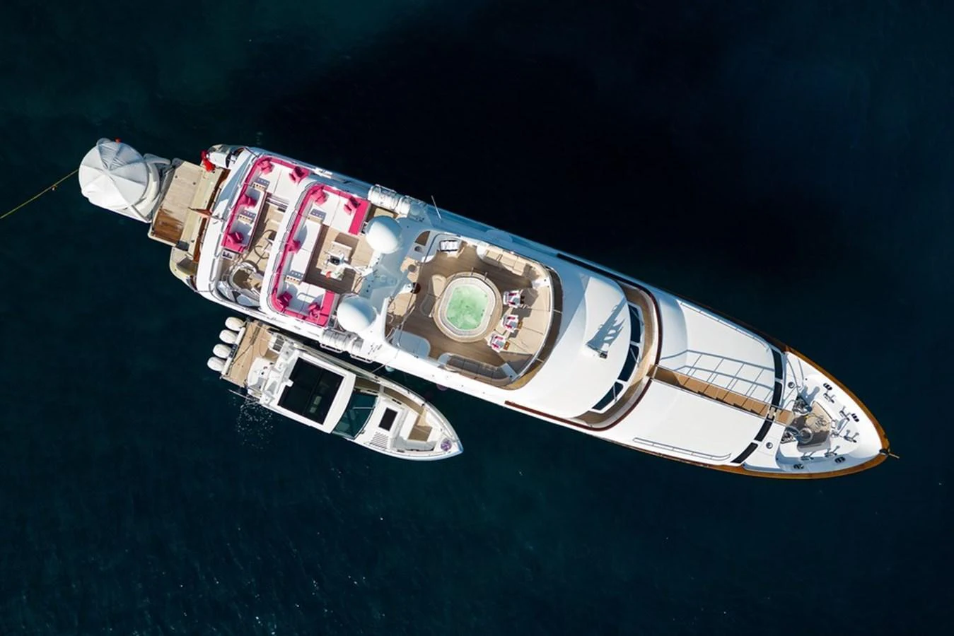 A luxurious yacht is anchored in calm waters, showcasing its spacious deck and amenities from an aerial view. aboard VIRTUE Yacht for Sale