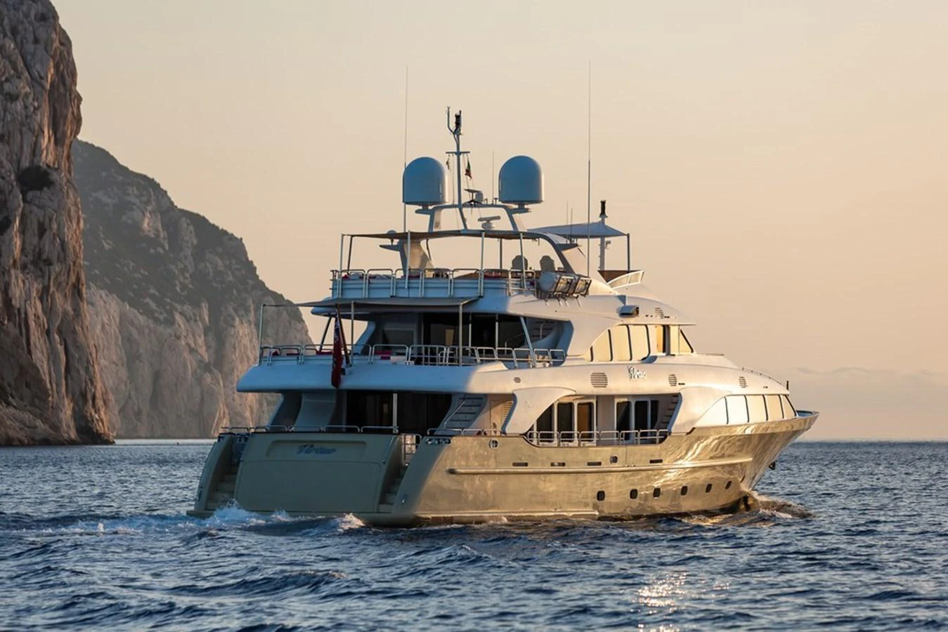 A luxurious yacht cruises through serene waters at sunset, showcasing its elegant design and spacious decks. aboard VIRTUE Yacht for Sale