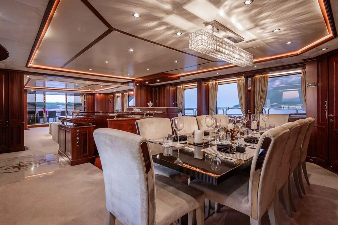 The yacht's dining area exudes elegance with its luxurious table setting and ambient lighting. aboard VIRTUE Yacht for Sale
