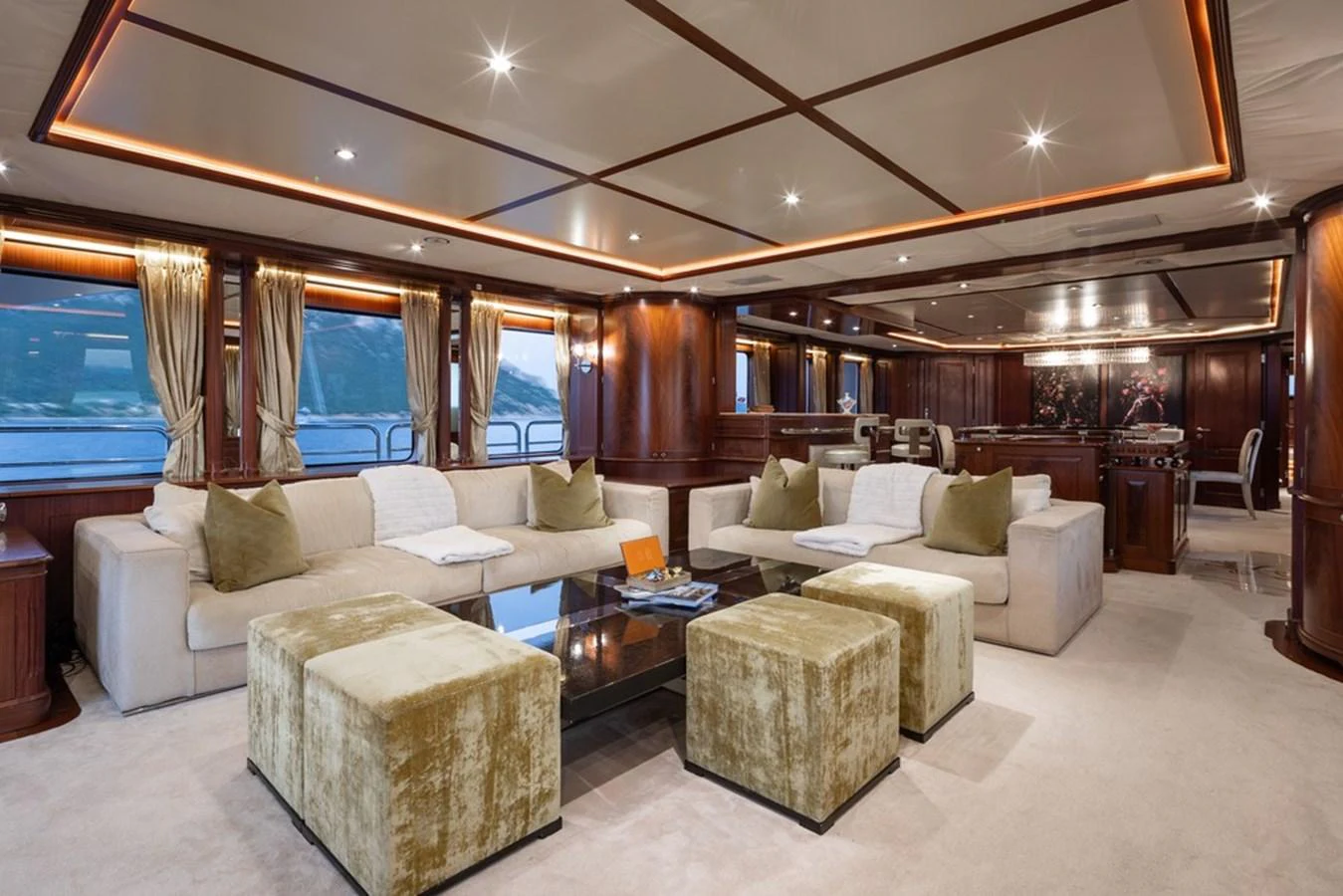 The salon features luxurious seating with plush furnishings and elegant wood paneling. aboard VIRTUE Yacht for Sale