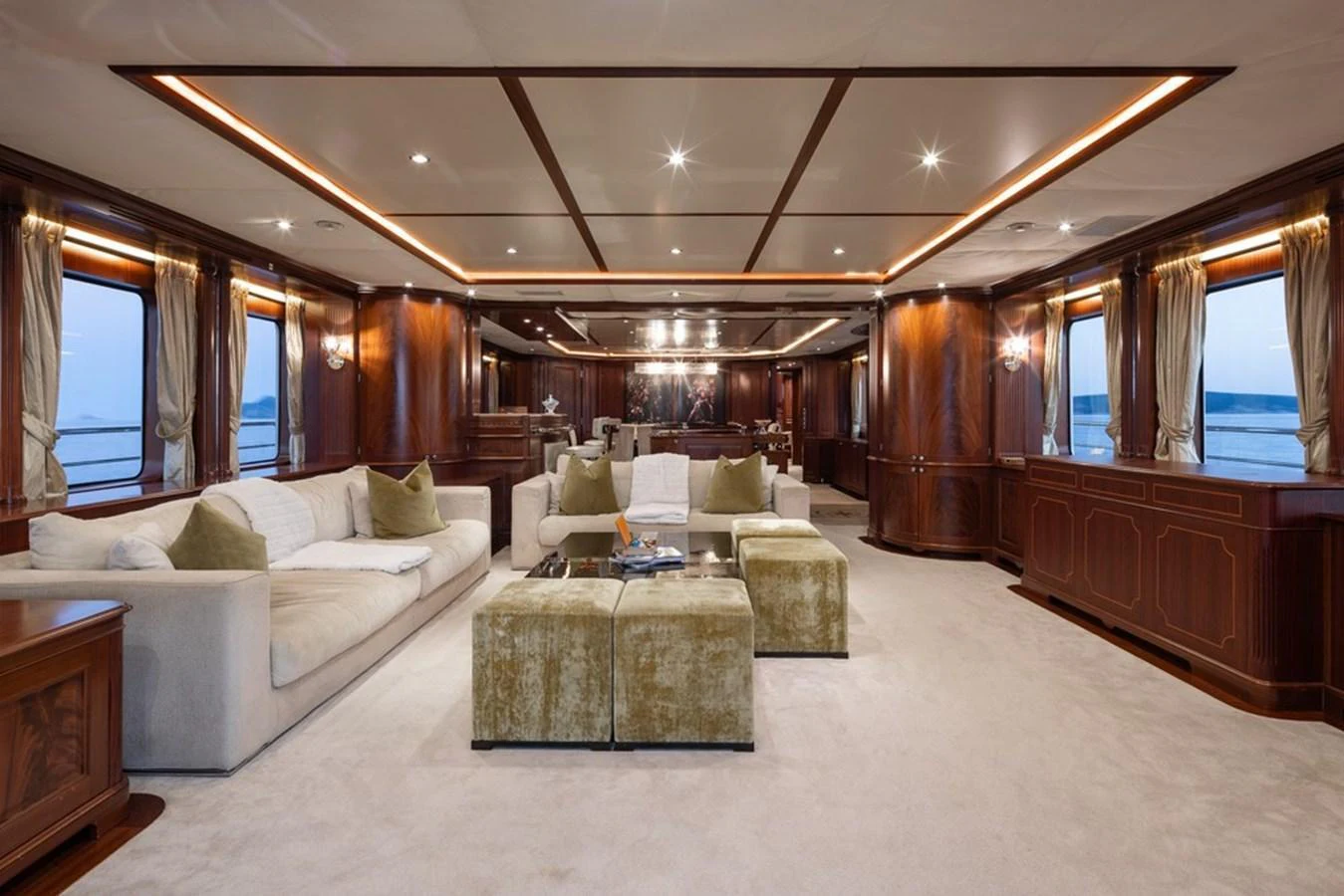 The spacious salon features luxurious seating and elegant wood paneling, creating a warm and inviting atmosphere. aboard VIRTUE Yacht for Sale