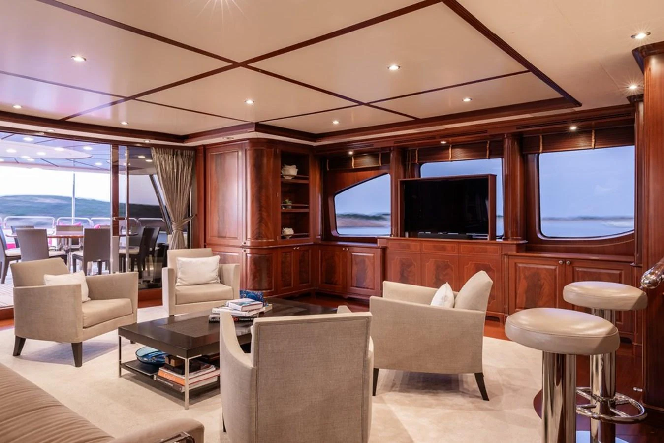 The yacht's salon features elegant wood paneling, plush seating, and a large flat-screen TV, creating a luxurious and inviting atmosphere. aboard VIRTUE Yacht for Sale