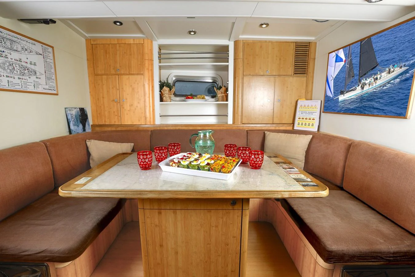 a living room with a couch and a table with food on it aboard CAPRICORNO Yacht for Sale