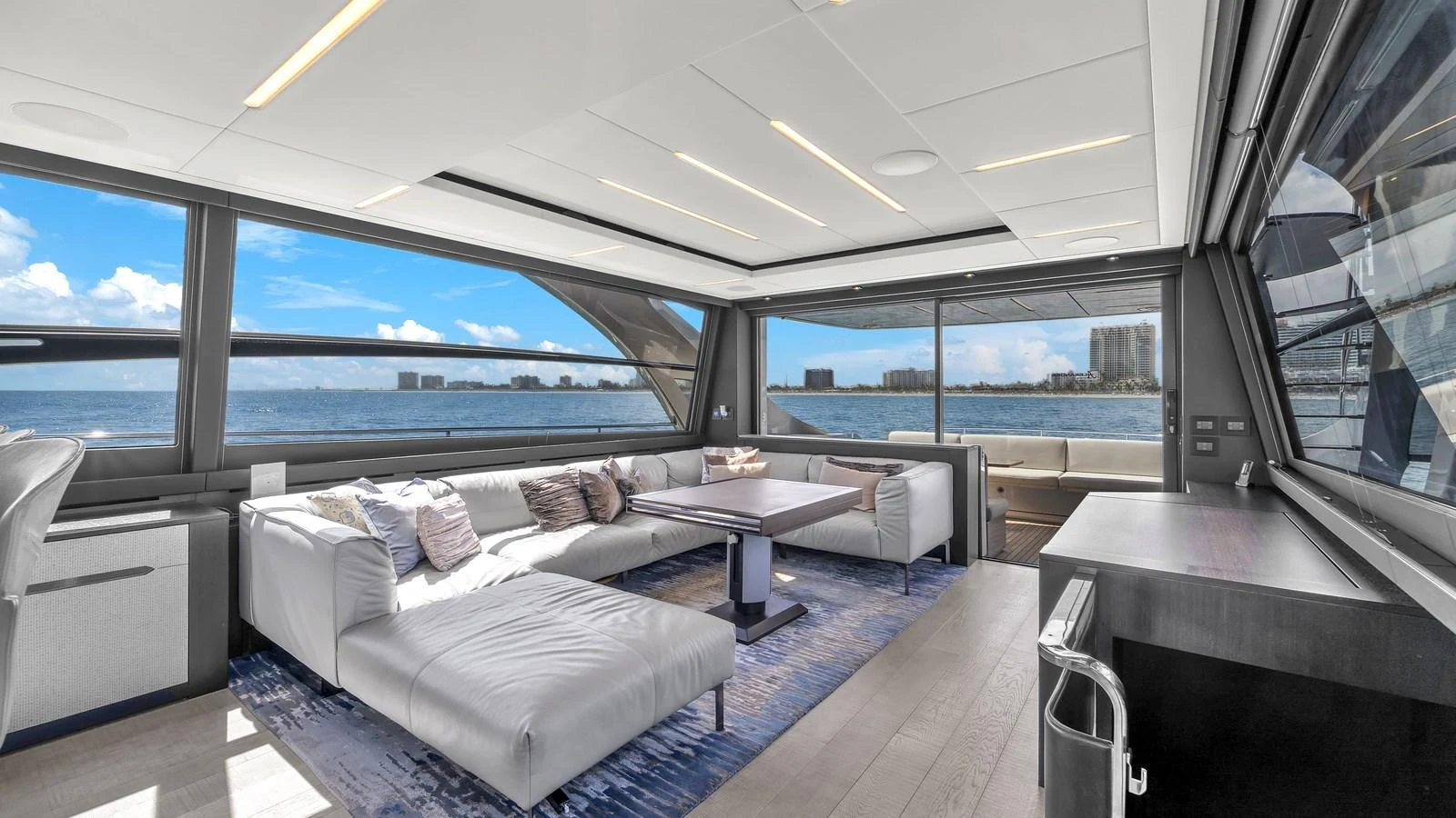a room with a couch and a table and a large window aboard ALEXANDRA Yacht for Sale