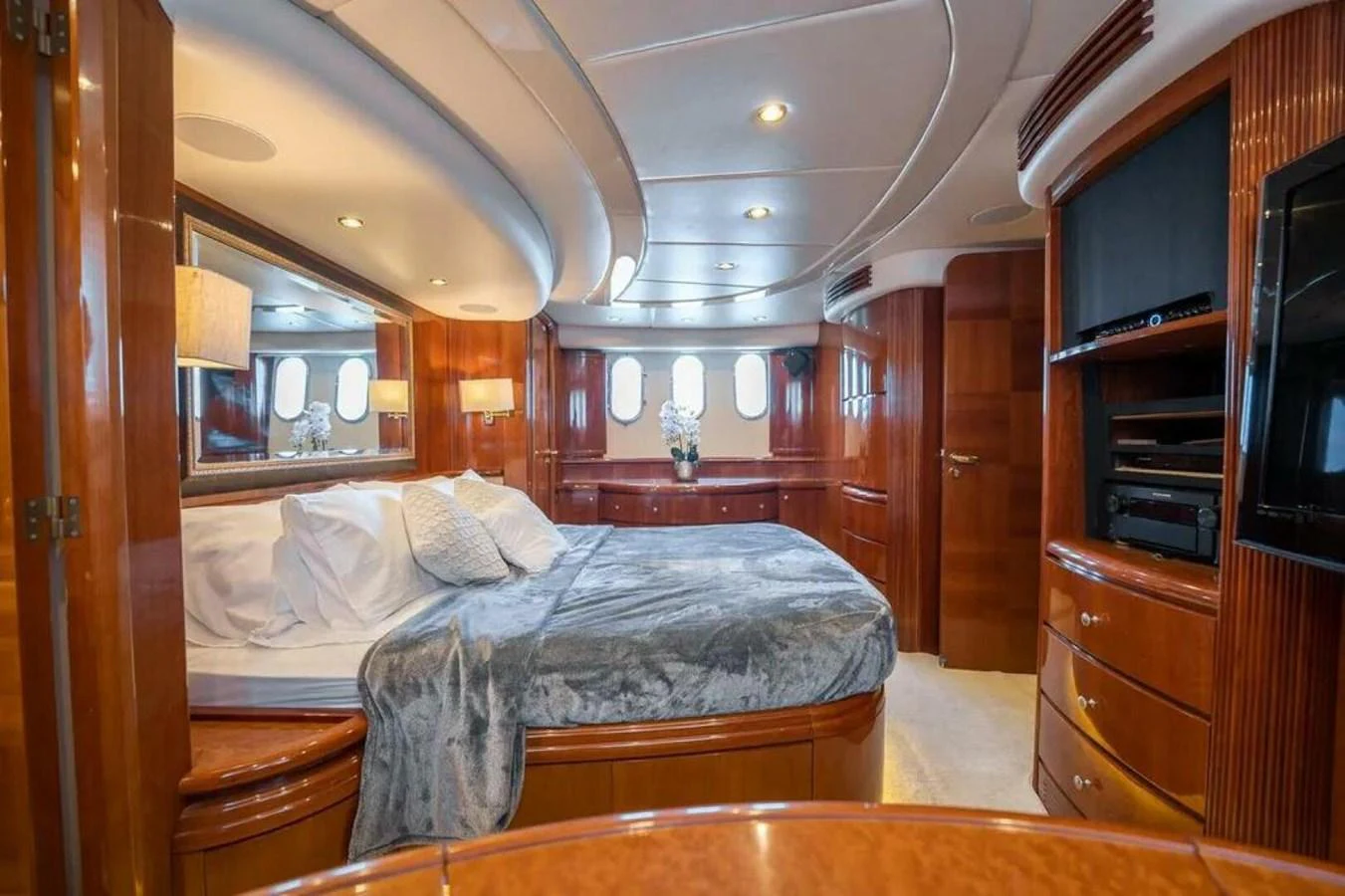 a bedroom with a bed and a wood cabinet aboard AZURE Yacht for Sale