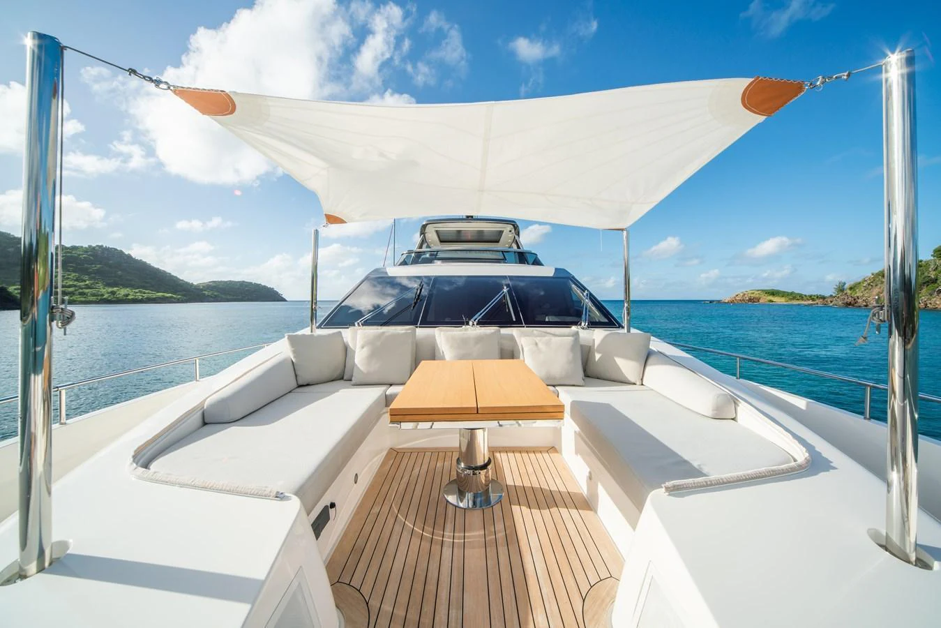 The yacht's aft deck features a spacious seating area with a central table under a sunshade, offering a perfect spot for relaxation and dining. aboard AKULA Yacht for Sale