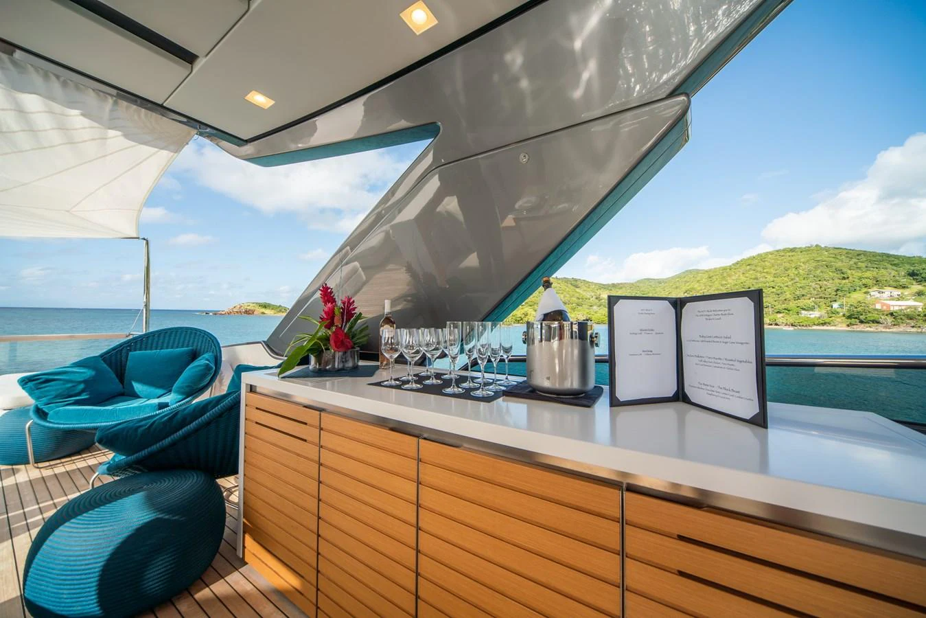A stylish outdoor bar area with a scenic view of the sea and surrounding landscape. aboard AKULA Yacht for Sale