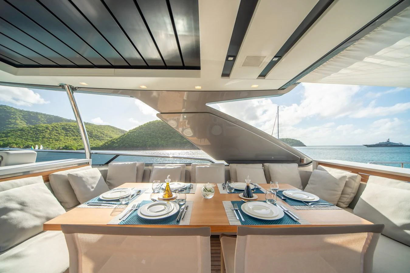 The yacht features a luxurious alfresco dining area with a stunning view of the sea and surrounding islands. aboard AKULA Yacht for Sale