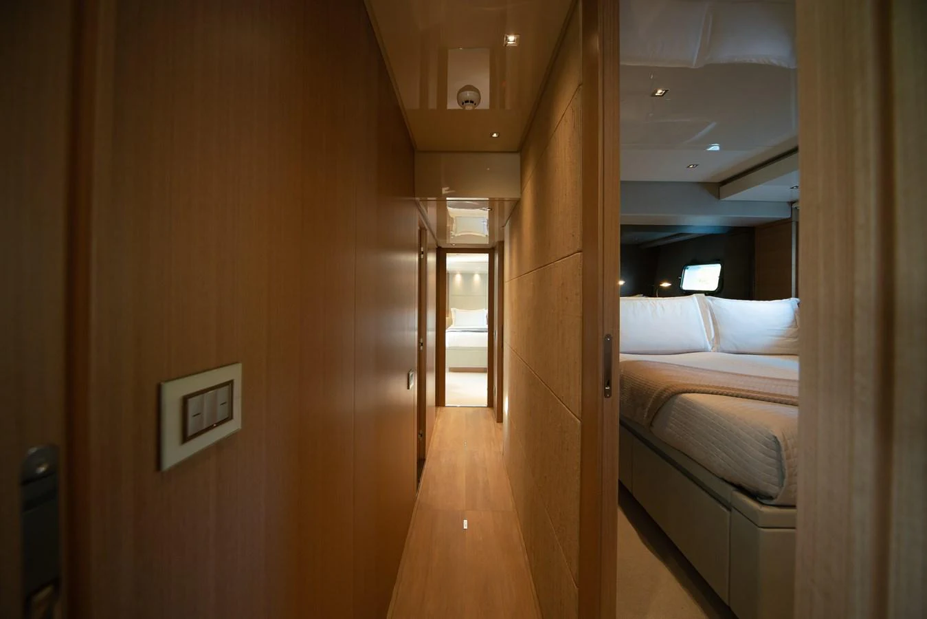 A cozy hallway leading to a luxurious bedroom with warm wooden finishes. aboard AKULA Yacht for Sale