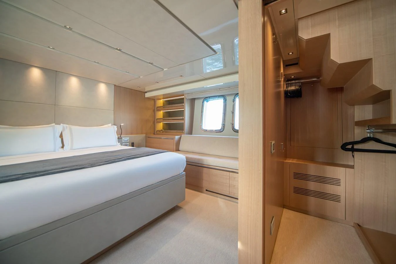 The stateroom features a luxurious bed, ample storage, and natural light from large windows. aboard AKULA Yacht for Sale