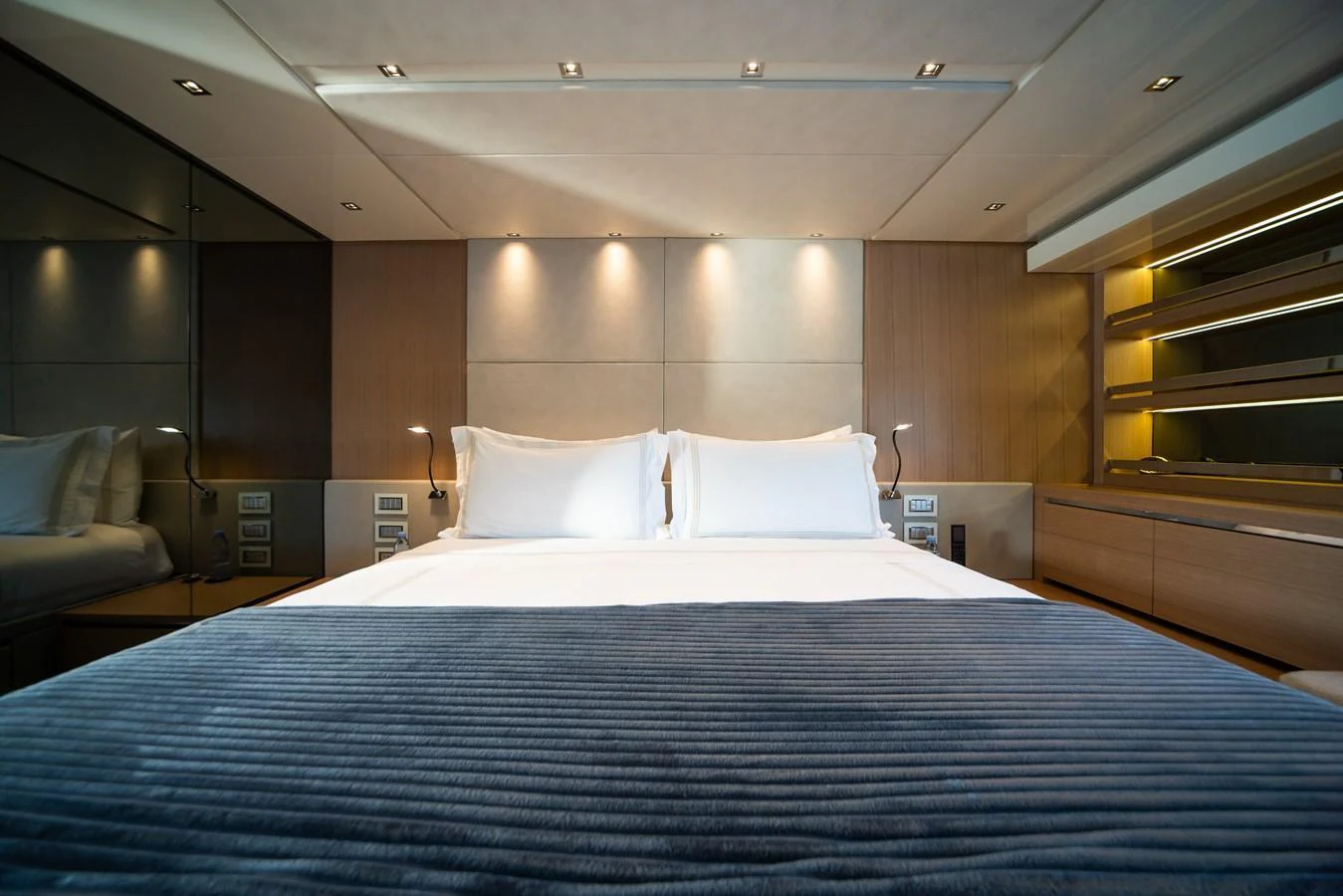 The stateroom features a luxurious bed with elegant lighting and modern decor. aboard AKULA Yacht for Sale
