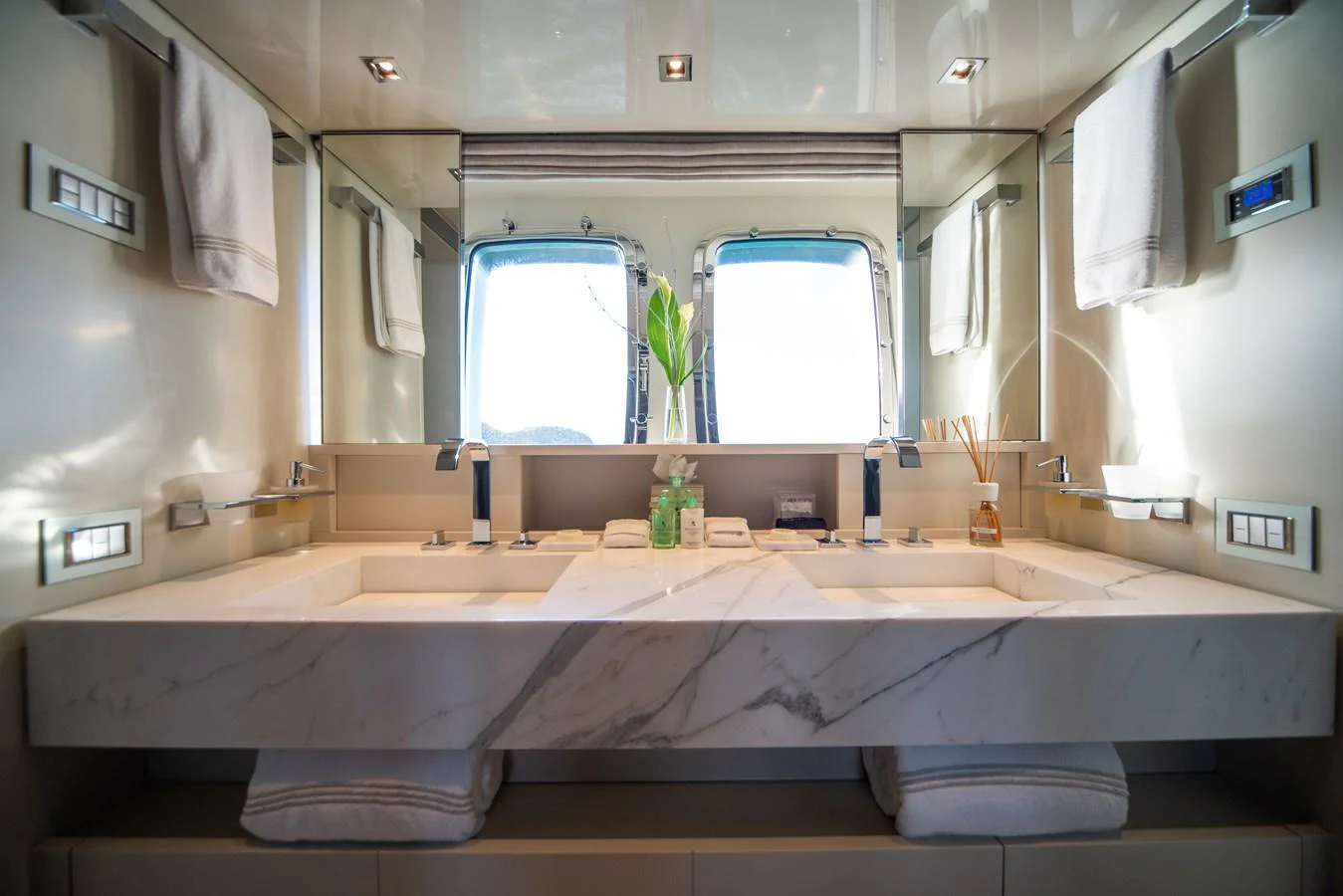 The yacht's bathroom features a luxurious double sink with a marble countertop and modern fixtures. aboard AKULA Yacht for Sale