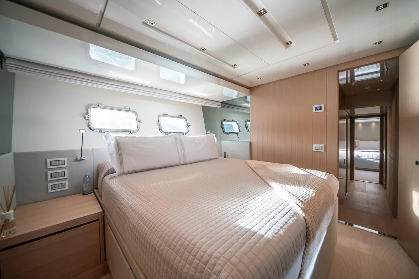 The stateroom features a spacious bed with ample natural light from the windows. aboard AKULA Yacht for Sale
