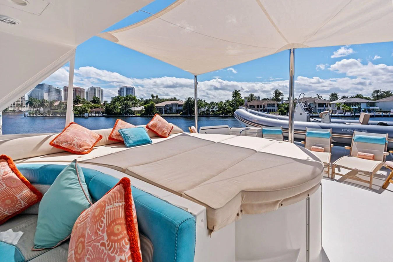 a lounge area with a large white tent and a view of a city aboard PICOSA LADY Yacht for Sale