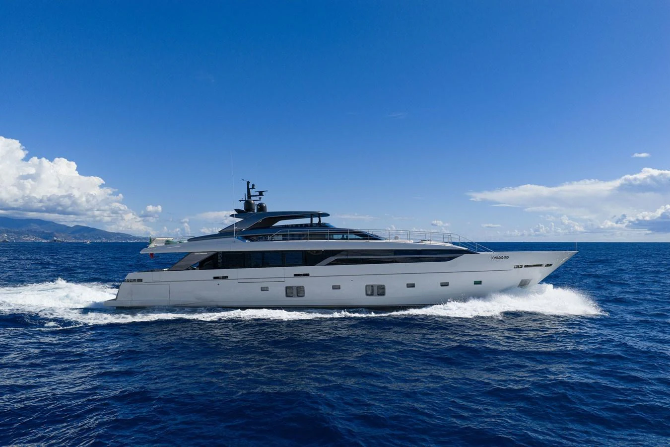 A sleek and modern yacht cruises through the open sea under a clear blue sky. aboard LADY LU' Yacht for Sale