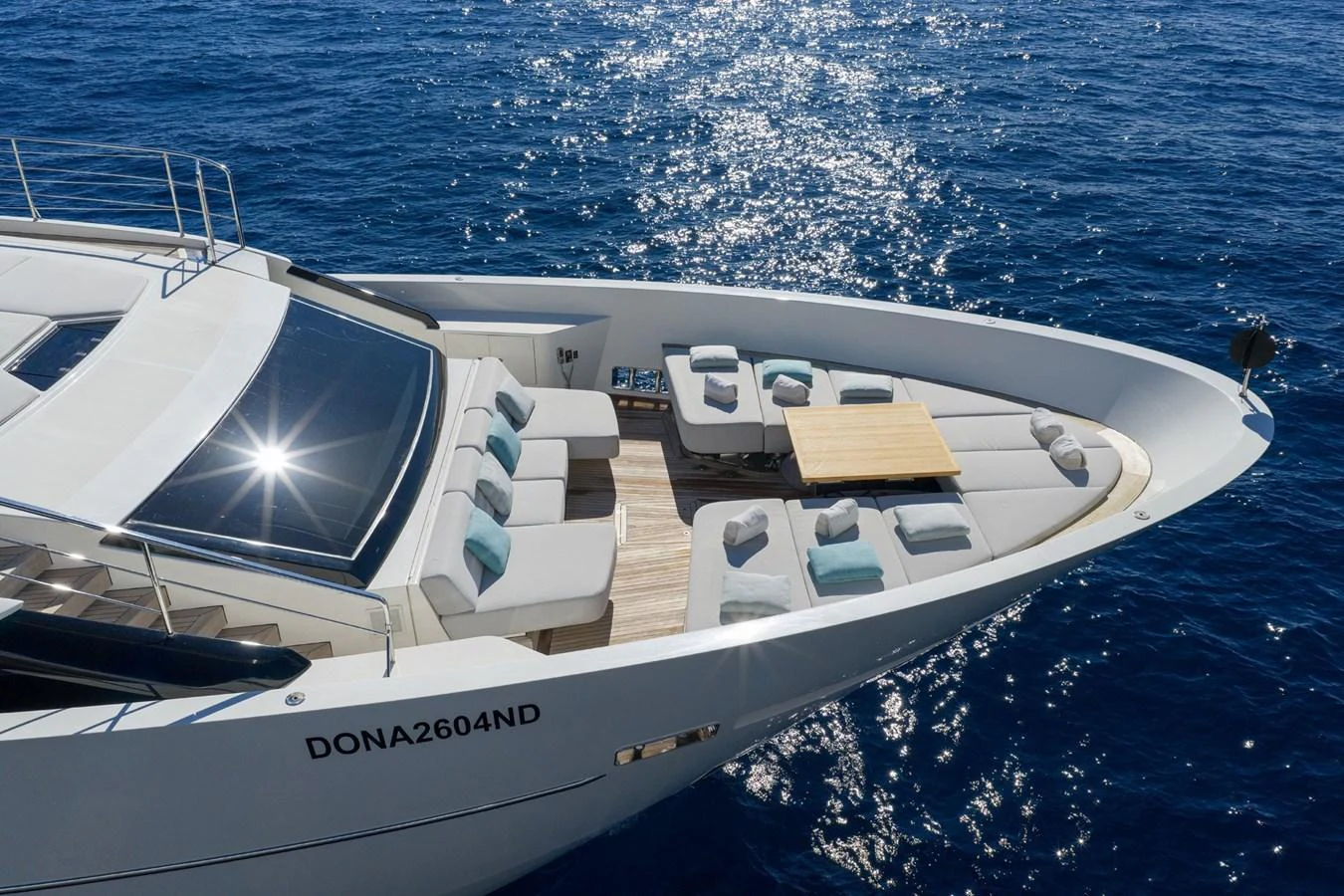 The yacht's foredeck features luxurious sun pads and a stylish seating area with a table, perfect for relaxation. aboard LADY LU' Yacht for Sale