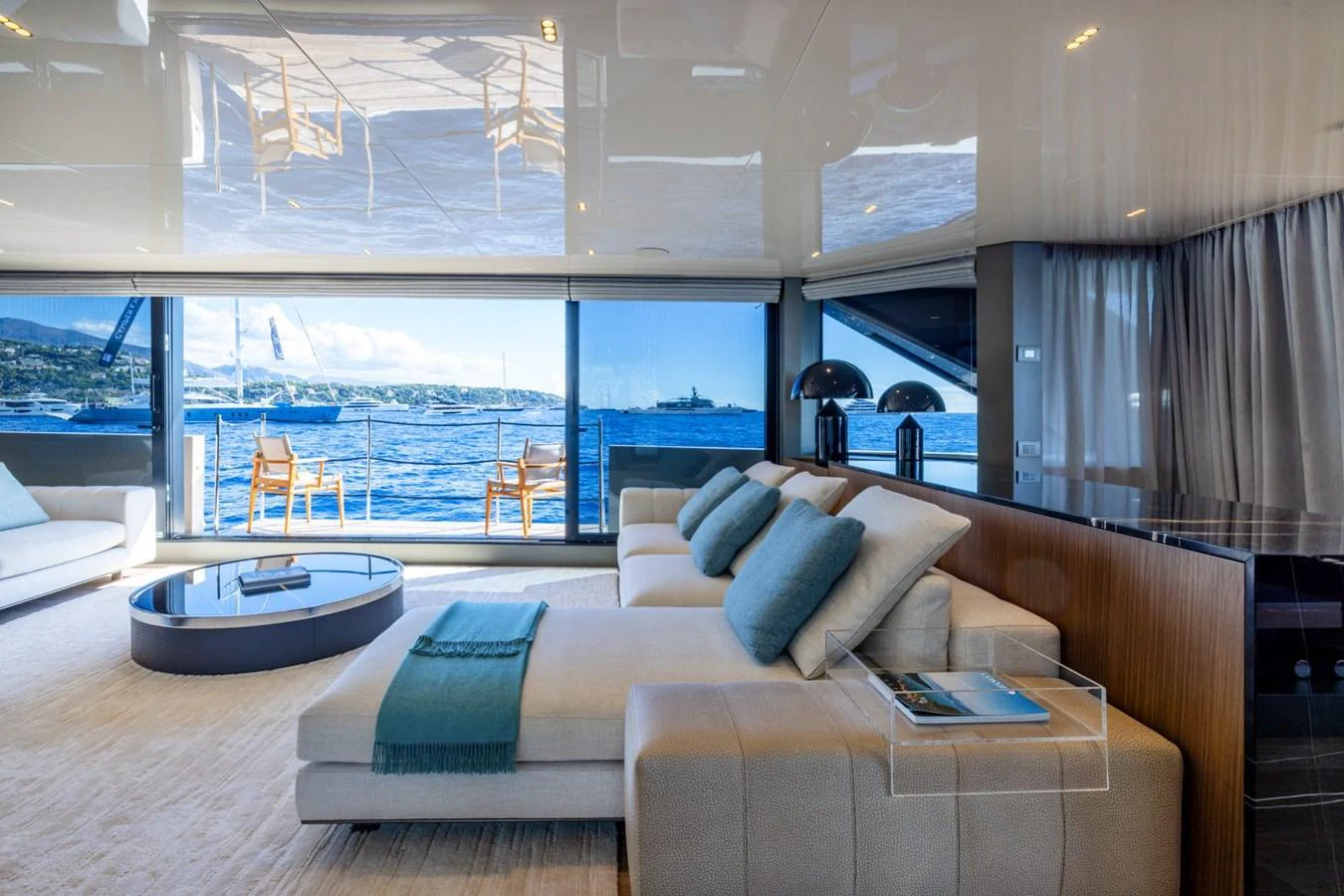 The salon features luxurious seating with a stunning view of the sea through large windows. aboard LADY LU' Yacht for Sale