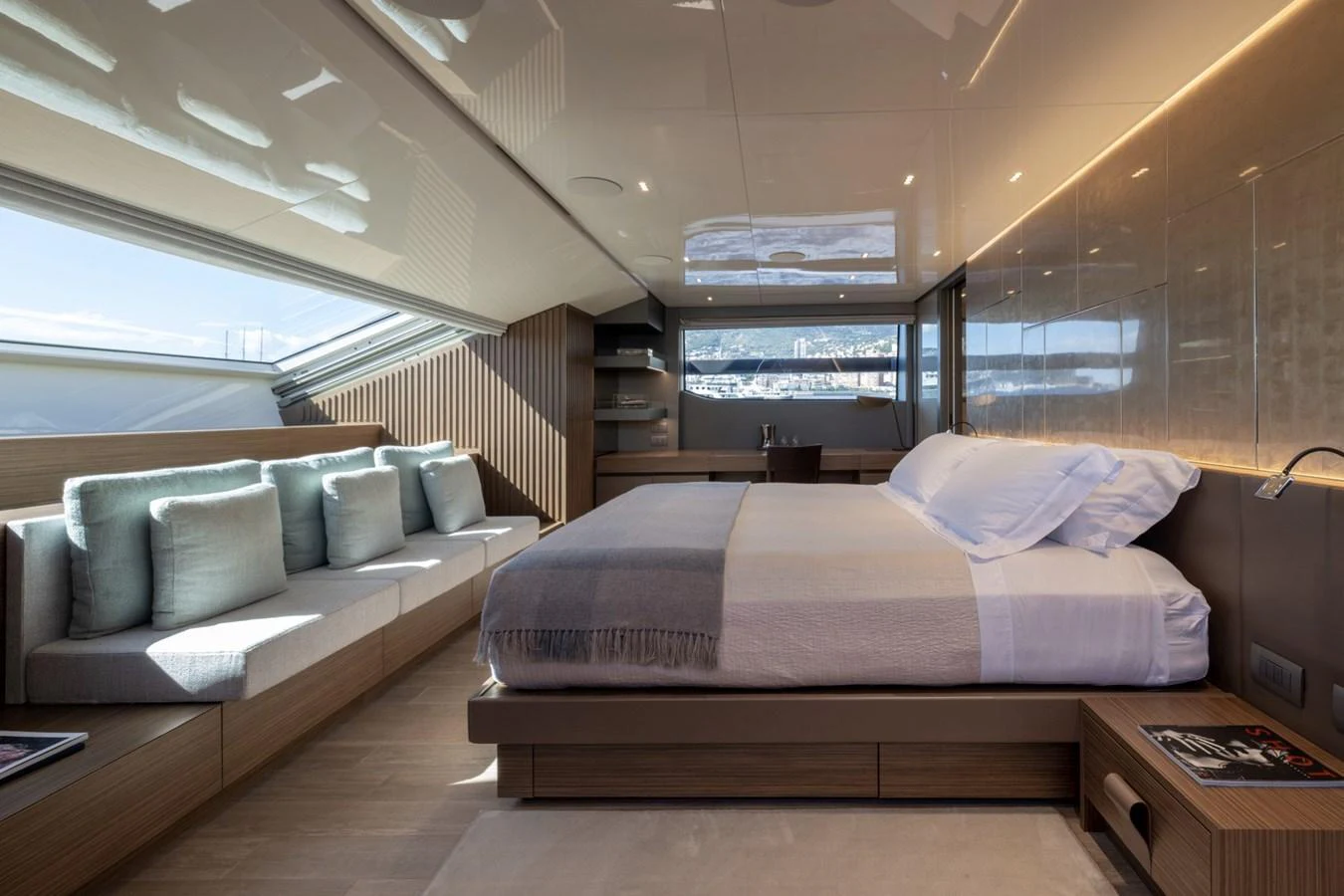 The master stateroom features a luxurious bed, ample natural light, and elegant wood finishes. aboard LADY LU' Yacht for Sale