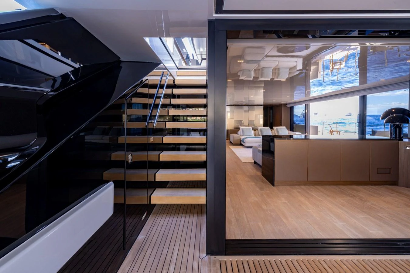 The image showcases a luxurious salon area with modern furnishings and a sleek staircase. aboard LADY LU' Yacht for Sale