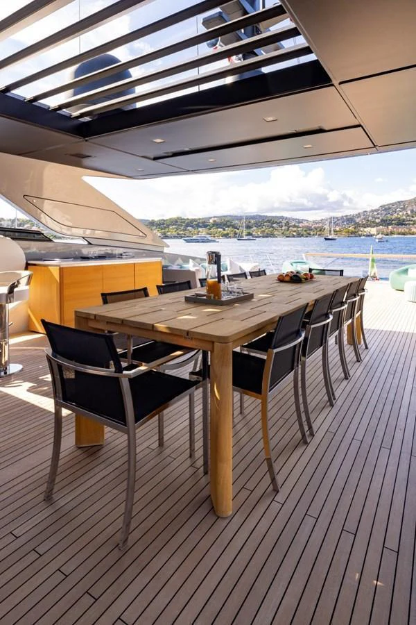 The aft deck offers a spacious dining area with a large table and comfortable chairs, perfect for alfresco meals with a view. aboard LADY LU' Yacht for Sale