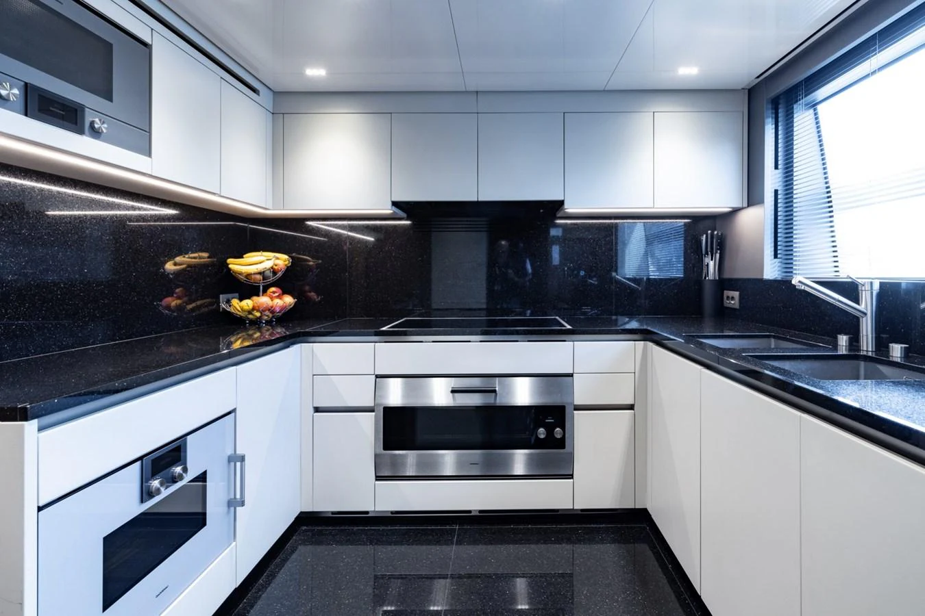 The modern galley features sleek cabinetry, high-end appliances, and ample counter space. aboard LADY LU' Yacht for Sale