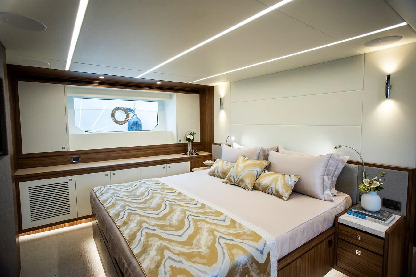 a bedroom with a bed and a mirror aboard 70' JOHNSON SKYLOUNGE 2026 Yacht for Sale