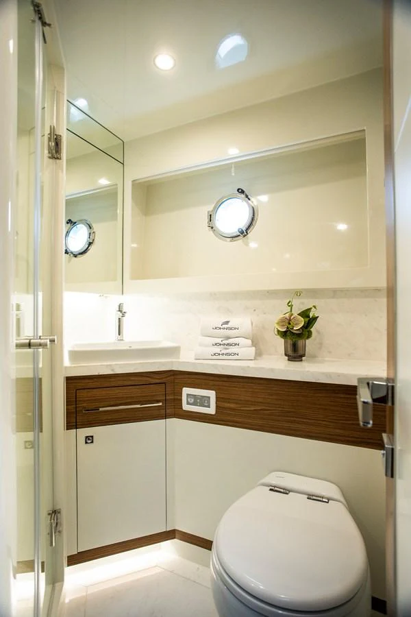 a bathroom with a toilet and a sink aboard 70' JOHNSON SKYLOUNGE 2026 Yacht for Sale