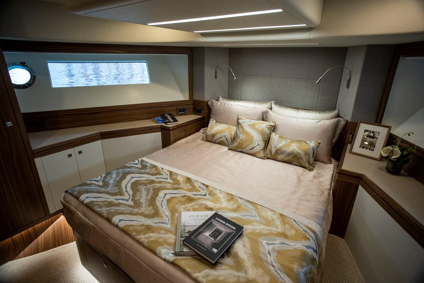 a bed with a phone on it aboard 70' JOHNSON SKYLOUNGE 2026 Yacht for Sale