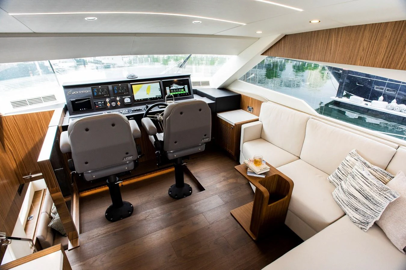 a room with a couch and a table and chairs aboard 70' JOHNSON SKYLOUNGE 2026 Yacht for Sale