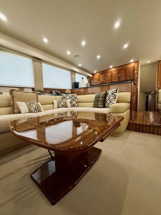 The yacht's salon features a luxurious seating area with plush cushions and a polished wooden table, creating a warm and inviting atmosphere. aboard KICKBACK Yacht for Sale