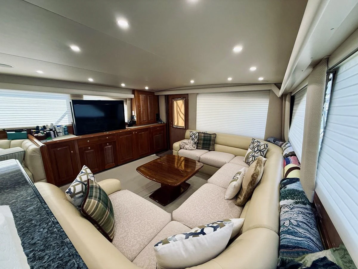 The salon features a spacious seating area with plush sofas and a large flat-screen TV. aboard KICKBACK Yacht for Sale