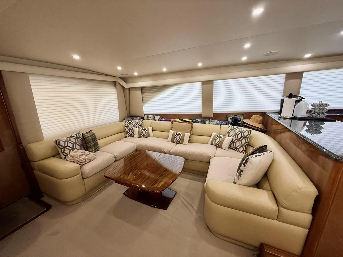 The salon features a spacious and comfortable seating area with plush cushions and a stylish wooden table. aboard KICKBACK Yacht for Sale