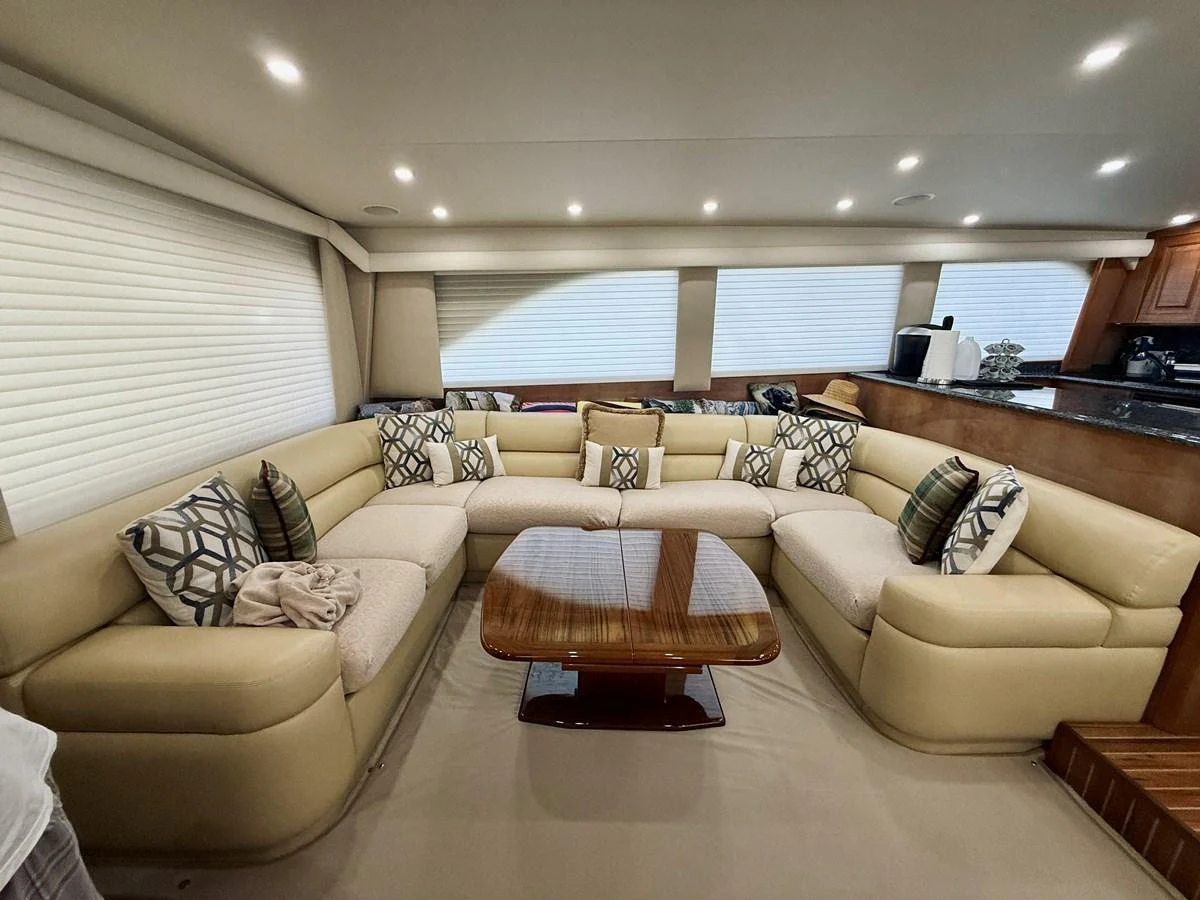 The salon features a spacious and comfortable seating area with a stylish wooden coffee table. aboard KICKBACK Yacht for Sale