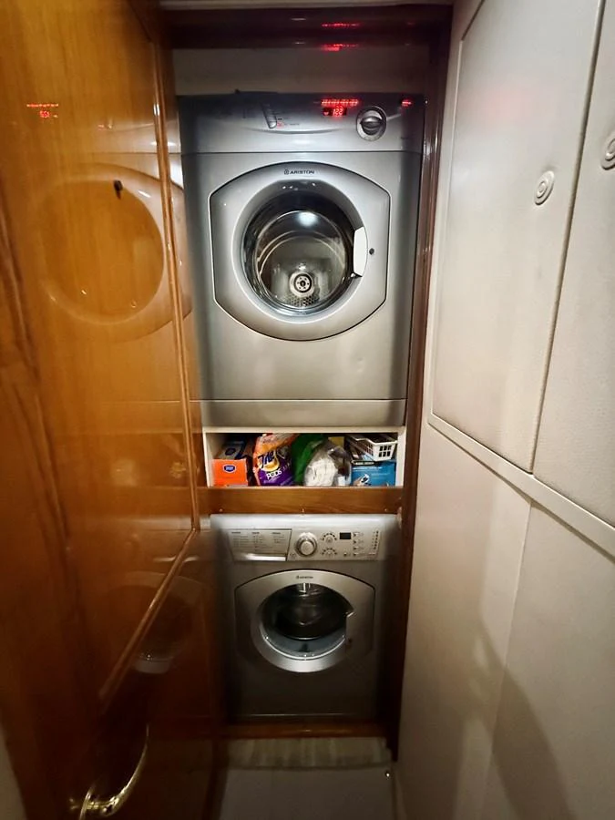 The yacht features a compact and efficient laundry room with modern appliances. aboard KICKBACK Yacht for Sale