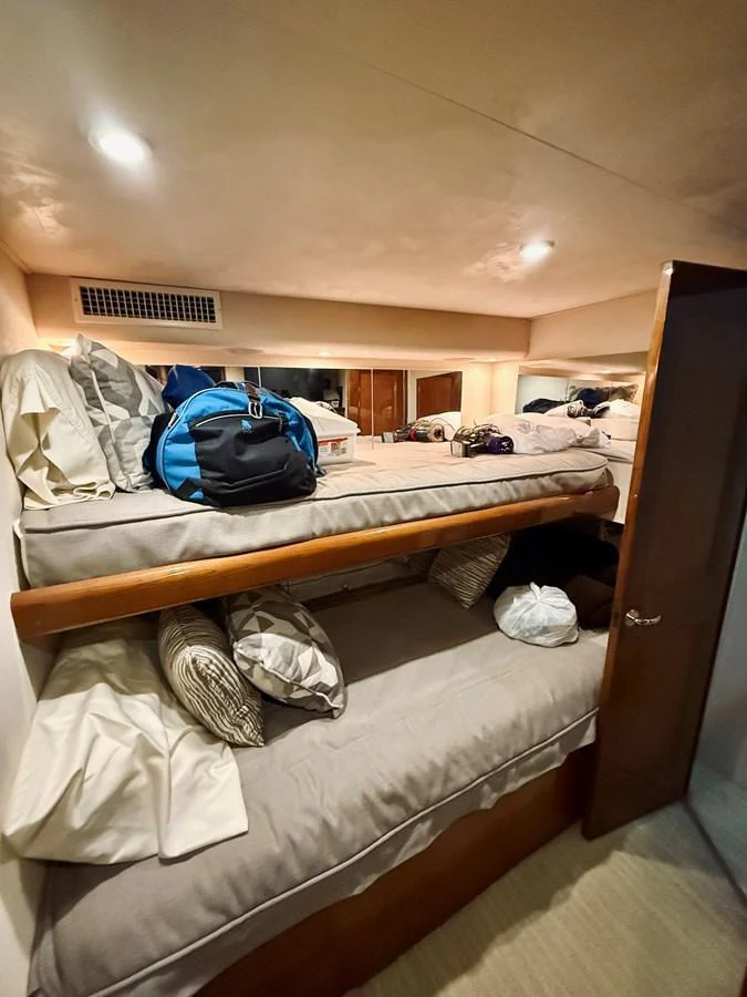 A cozy cabin with bunk beds and personal belongings, perfect for a restful night at sea. aboard KICKBACK Yacht for Sale