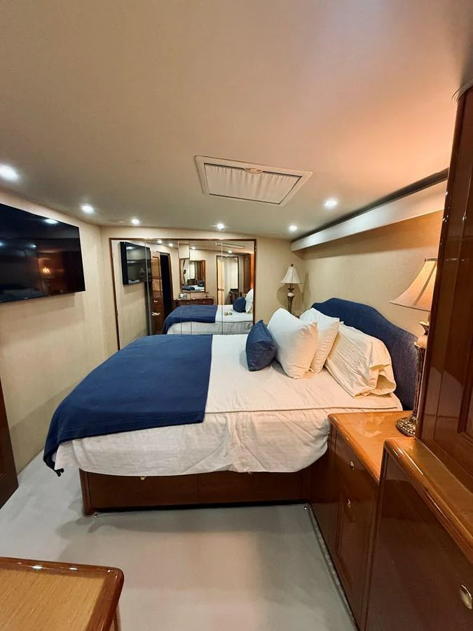 A cozy stateroom featuring a comfortable double bed with plush bedding and ambient lighting. aboard KICKBACK Yacht for Sale