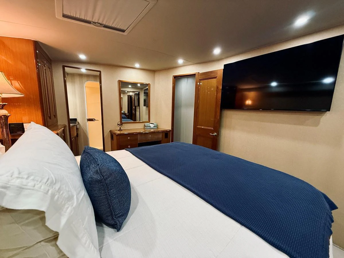 The stateroom features a comfortable bed with elegant bedding and modern amenities. aboard KICKBACK Yacht for Sale
