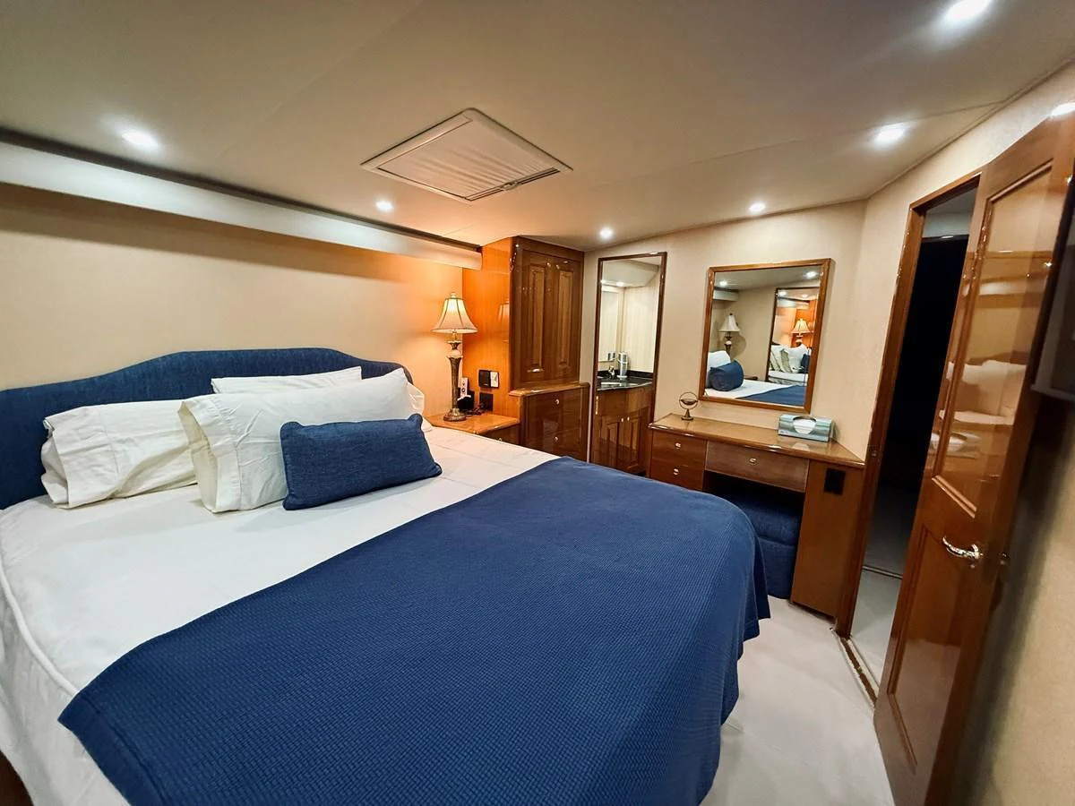 The stateroom features a comfortable bed with elegant bedding and ample storage space. aboard KICKBACK Yacht for Sale